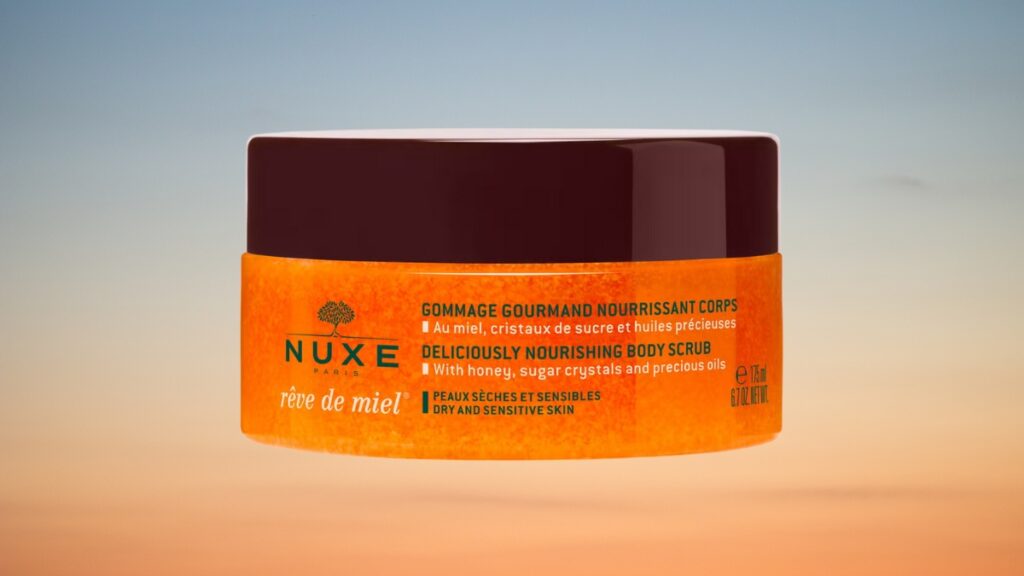 NUXE Rêve de Miel body scrub jar shown with label highlighting honey, sugar crystals, and oils for dry and sensitive skin.