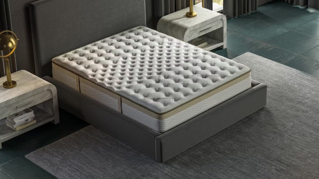 Saatva mattress on a dark grey bed frame with a tufted organic cotton cover in a stylish modern bedroom.