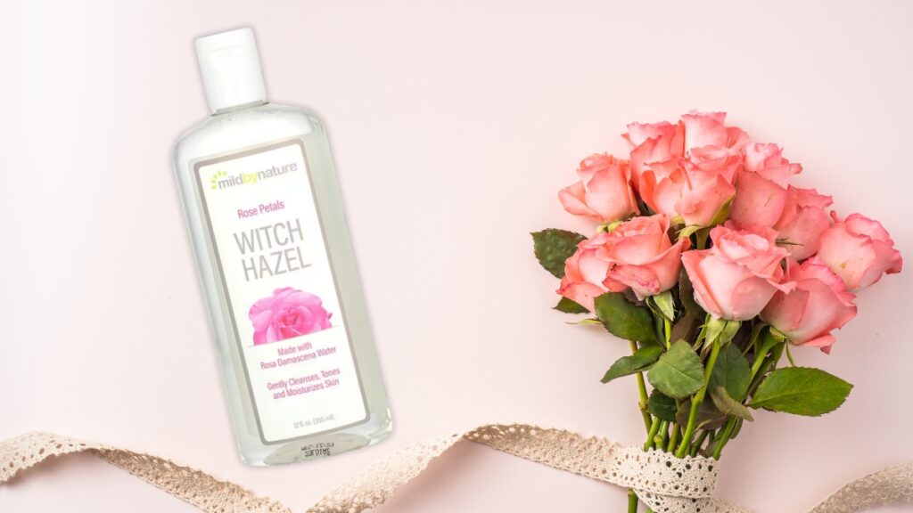Mild By Nature Witch Hazel Rose Petals Toner bottle placed next to pink roses, a gentle skincare essential made with rose water.