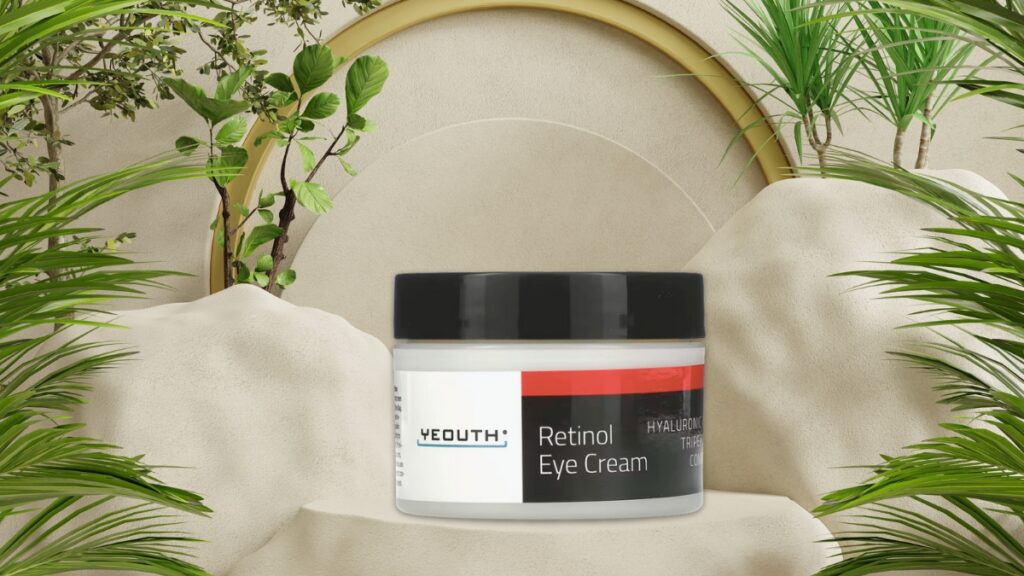Yeouth Retinol Eye Cream jar placed on a soft beige surface with greenery, a skincare product made to smooth fine lines and reduce puffiness.
