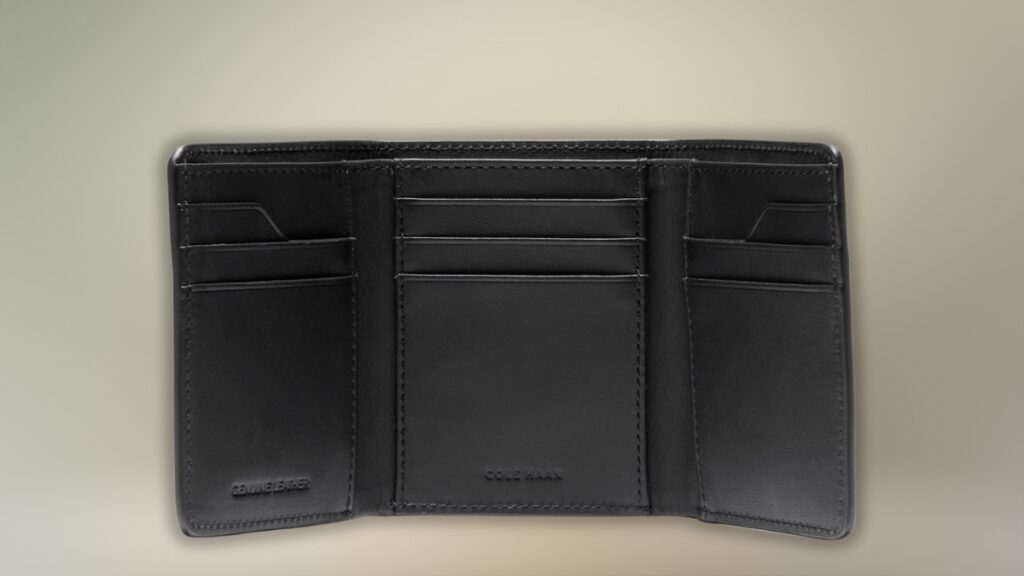 An open black Cole Haan leather wallet showing multiple card slots and a clean trifold design.