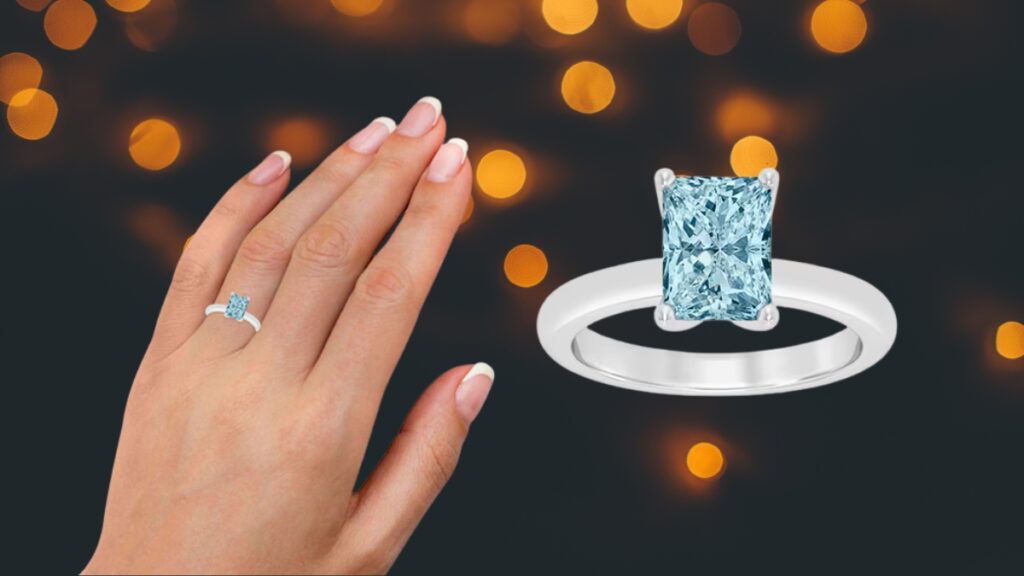 A white gold engagement ring with a radiant cut light blue diamond shown on a hand and in a close-up view.